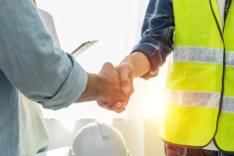 Contractor. construction worker team hands shaking after plan project contrac Stock Photos