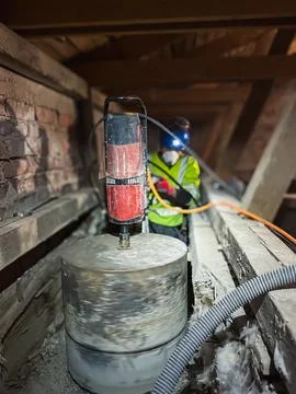 Contractor core drilling structural opening in concrete floor slab. Foto stock