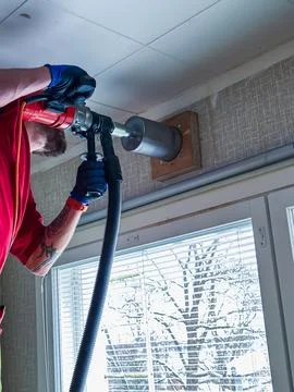 Contractor drilling through wooden structural beam during interior home ren.. Stock Photos