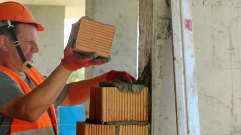 Contractor in hard hat installs material to create structure Stock Footage 317627622