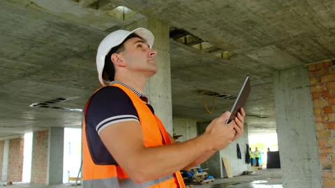 Contractor holding tablet inspecting building constructions Stock Footage 317618086