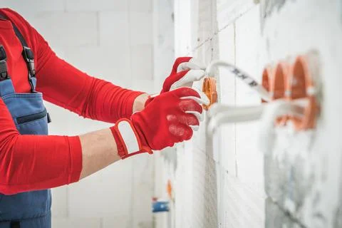 Contractor Installing Electric Wall Power Sockets Inside Residential Building Foto stock