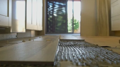 A contractor installing floor tile in a kitchen Stock Footage 106793244