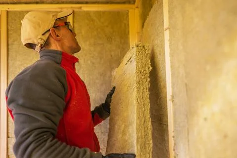 Contractor Installing Mineral Wool Insulation Stock Photos