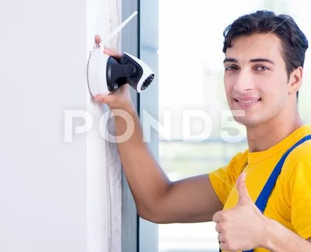 Contractor installing surveillance CCTV cameras in office Stock Photos