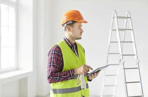 Contractor Planning Renovation Using Tablet Pc And Estimating Costs 스톡 사진