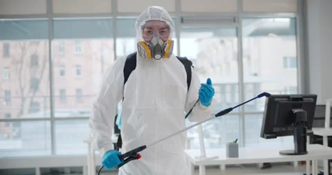 Contractor in safety uniform disinfecting office killing covid-19 virus Stock Footage 147388127