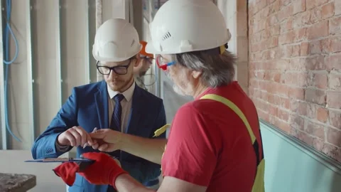 Contractor signing document for foreman on construction site Stock Footage 133636854