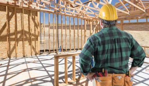 Contractor Standing Inside Construction Framing of New House. Stock Photos