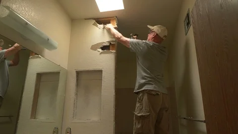 A contractor tearing out a wall on a home remodeling project Stock Footage