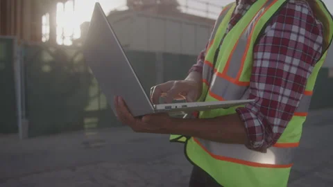 Contractor Types on Computer at Construction Site in Bright Sunshine Stock Footage 208783314