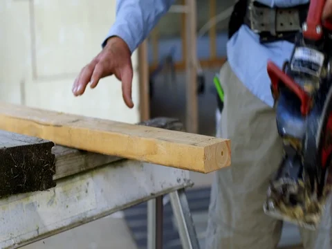 Contractor uses power saw to cut a plank of wood in slow motion 4K Stock Footage 80405674