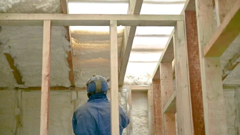 Contractor uses spray equipment to insulate interior wall with expanding foam Stock Footage 346550688