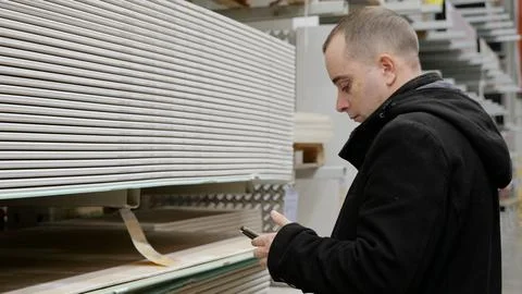 Contractor using a smartphone for selecting construction materials in a Fotos de archivo