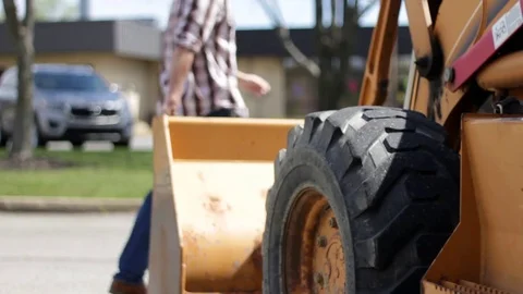 Contractor walks infront of Excavator machine in daylight Stock Footage 74605230
