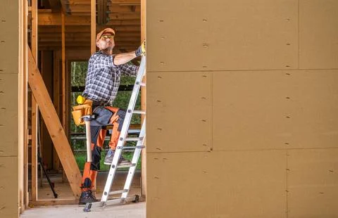Contractor Worker Inside Newly Built Wooden House Frame Фото