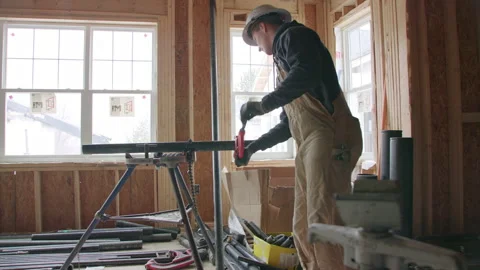 Contractor working on house cutting pipe Stock Footage 228489672