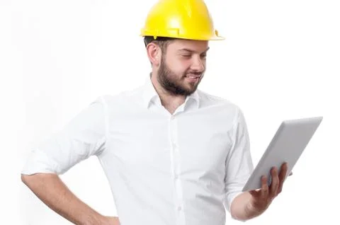 Contractor in yellow helmet working on a project with tablet. Business man in Фото