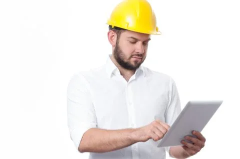 Contractor in yellow helmet working on a project with tablet. Business man in Фото