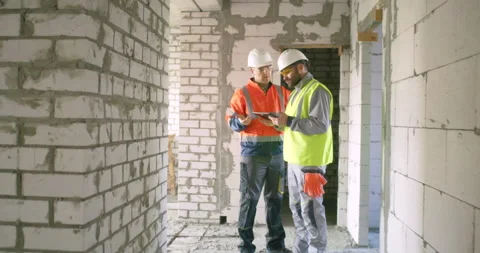 Contractors discussing construction data on tablet in corridor Stock Footage 142336485