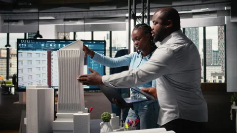 Contractors team reviews structural layout 3D models plan for urban development Stock Footage 316654037