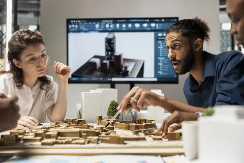Contractors team reviews structural layout 3D models plan for urban development Stock Photos