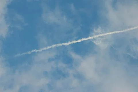 Contrail in Blue Sky with Clouds Stock-Fotos