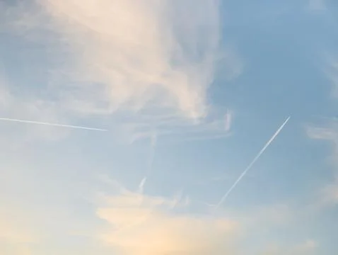 Contrail left by an airplane on a dramatic sky at sunset. Stock-Fotos