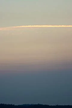 A contrail over clouds at sunset Stock Photos
