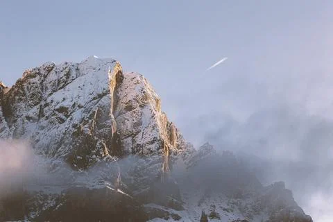 Contrail over a snowy summit Stock Photos