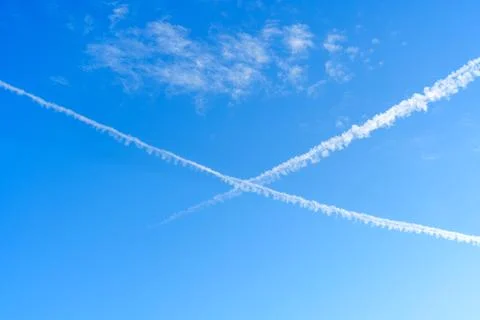 Contrails Forming Patterns Across a Clear Blue Sky Fotos Stock