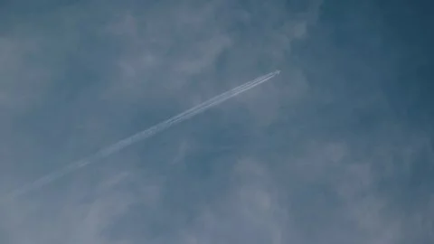 Contrails Stretching Across Cloudy Sky Video stock 303385504