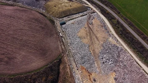 Contrast between agricultural field and massive garbage dump Vídeos de archivo 338187902