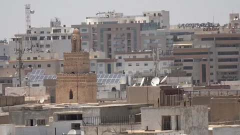 Contrast between historic mosque and modern offices, Sfax skyline Tunisia Stock Footage 345038427