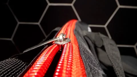 The contrast between the red zipper and the black fabric of the bag highlights Stock Footage 296376806