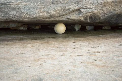 Contrast of a spherical shape of a buoy embedded in a crack in a rock Stock Photos