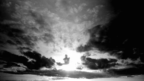 Contrasted black and white cloudscape in timelapse. Sun shines behind the clouds Stock Footage 87307384