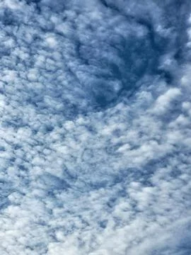 Contrasting white mackerel pattern clouds over deep blue sky Stock Photos