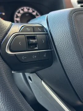 Control buttons located on the left side of a vehicle's steering wheel Stock Photos