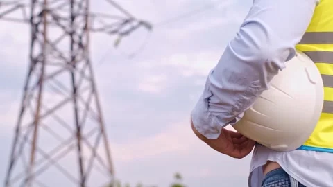 Control engineer with tablet pc, power lines and pylons, discussing expansion pl 스톡 동영상 252667361