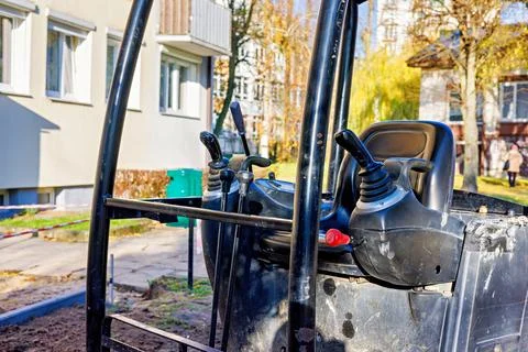 Control levers of a mini excavator in an open cab. Stock Photos