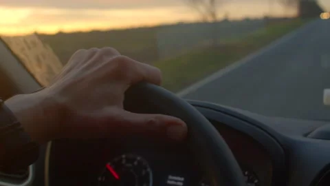 Control maintained during sunset on rural road with watch visible Stockbeeldmateriaal 334119495