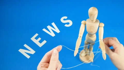 Control a marionette by strings on fingers and word news on blue background,  Stock Footage 131848300