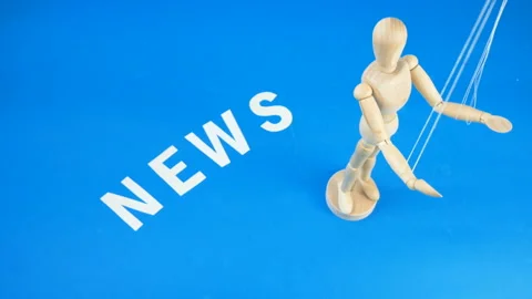 Control a marionette by strings on fingers and word news on blue background,  Stock Footage 131848666