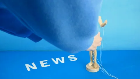 Control a marionette by strings on fingers and word news on blue background Stock Footage 148390099