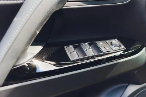 Control panel in the car door. Car door handle with adjustment knobs. Stock Photos