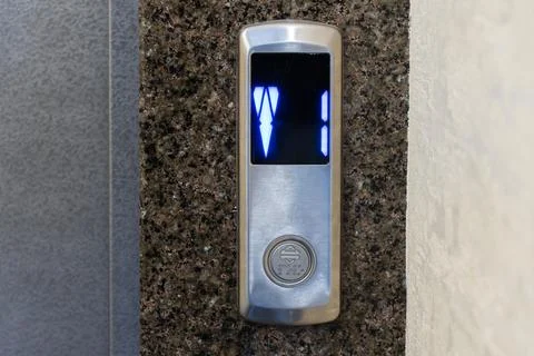 Control panel displays illuminated buttons indicating elevator direction an.. 库存照片
