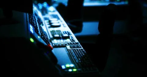 Control panel glows softly in darkened room of modern broadcast studio Stock Illustration