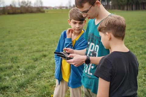 The control panel is in the hands of the boy who controls the drone. Children Stock Photos