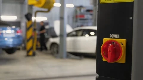 The control panel with the red button of the car lift at the service station. Video stock 256073383